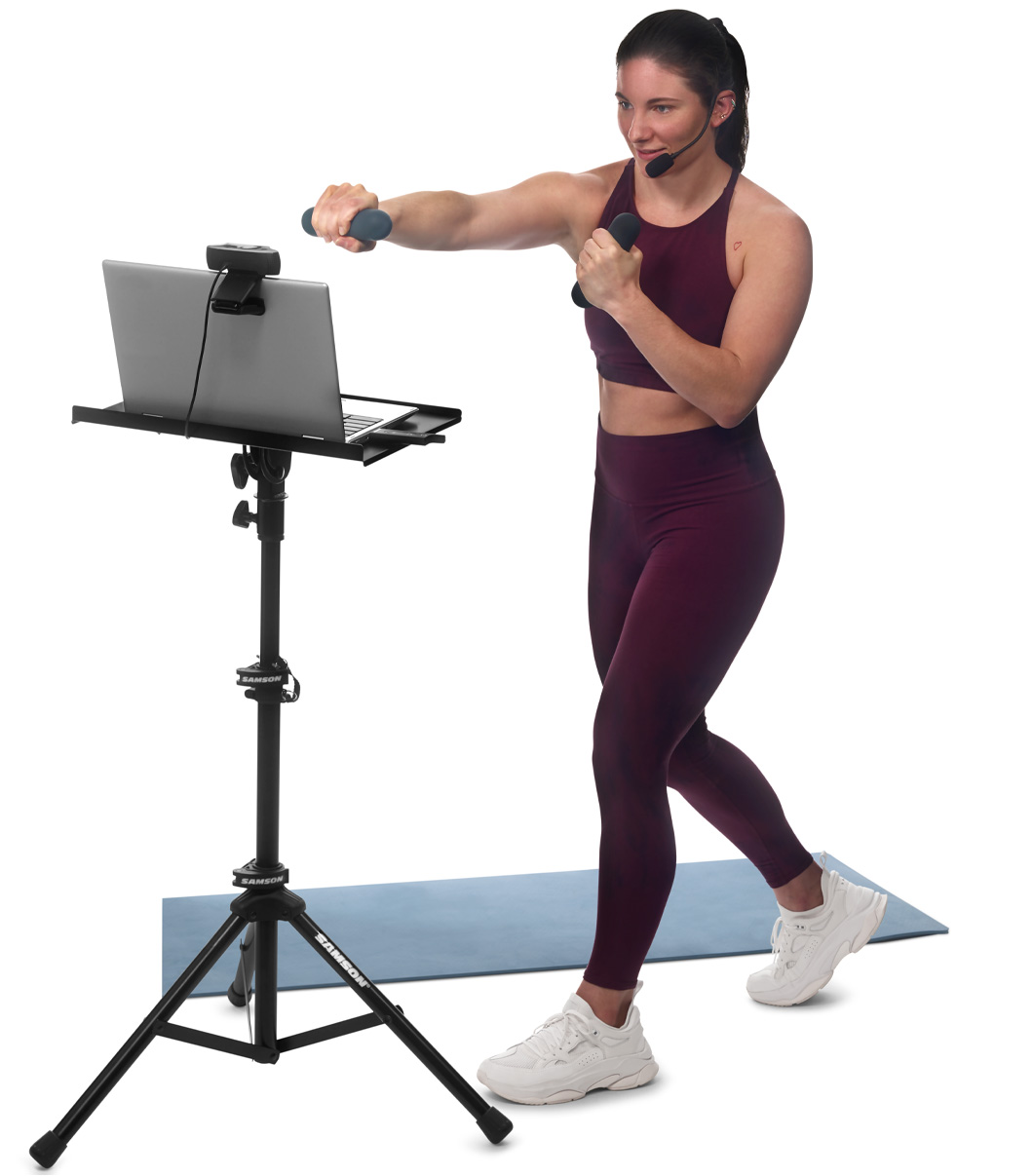 Fitness instructor wearing AirLine XD headset filming in front of laptop